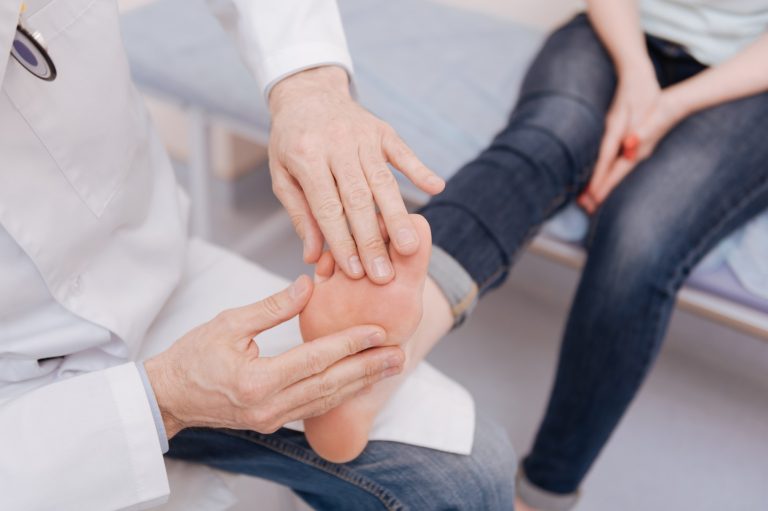 A rheumatologist examines a pediatric patient's foot