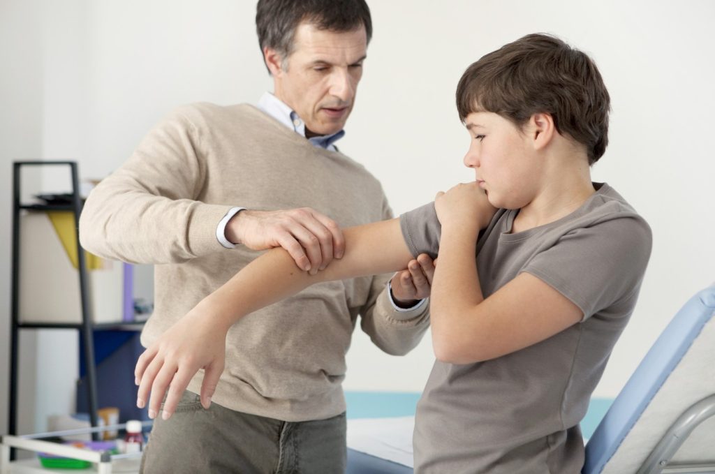 Pediatric rheumatologist helping a patient