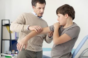 Pediatric rheumatologist helping a patient