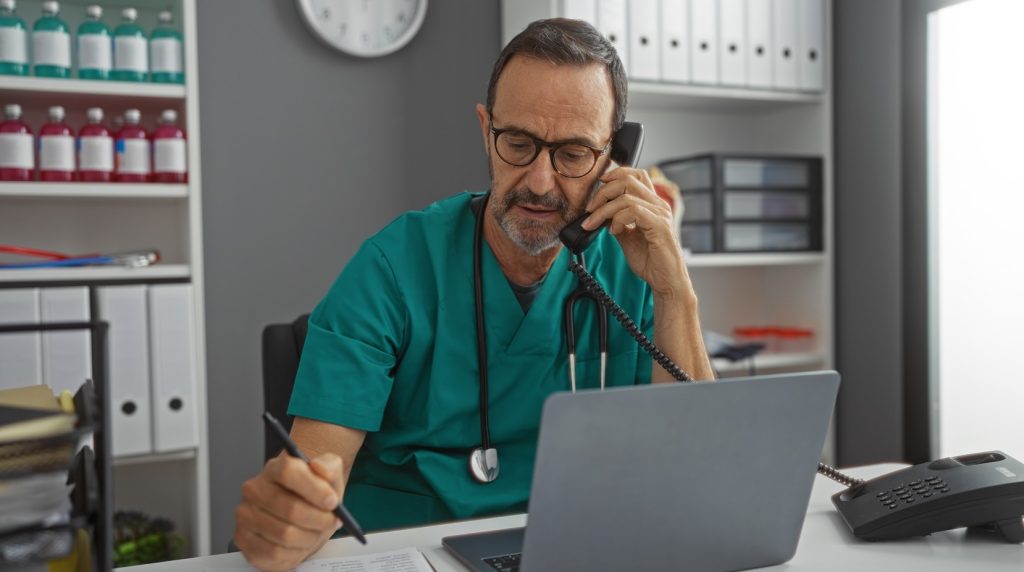 A doctor on the phone making a referral